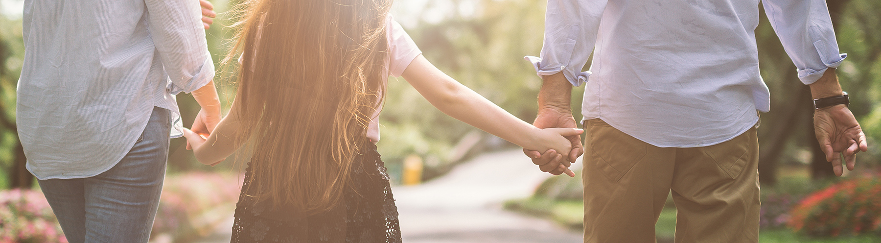 Parents hold hands with daughter